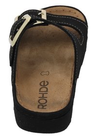 Sandale noire à semelle glissante avec un orteil courbé et deux sangles, dotée d'une boucle en métal argenté. Semelle intérieure beige rembourrée avec un logo imprimé.