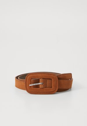 Ceinture en daim marron avec une boucle rectangulaire et une ardillon en métal argenté, roulée sur une surface blanche.