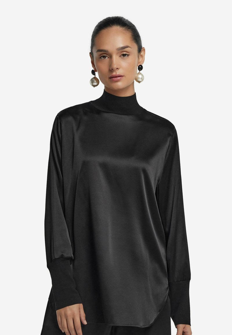 Schwarzes Satin-Oberteil mit langen Ärmeln, hohem Kragen, lockerem Schnitt und weitem Bund. Glatte Textur, minimalistisches Design.