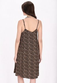 Rochie neagră cu imprimeu floral, cu flori mici roz și albe, bretele subțiri ajustabile și un design lejer în A. Textura materialului este moale.