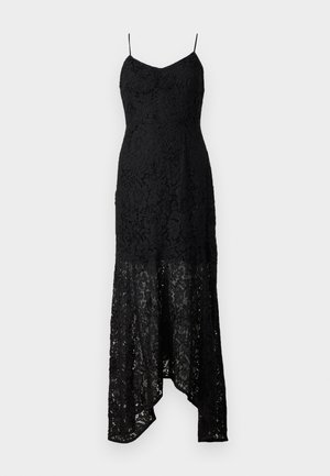 Juoda nėriniuota suknelė su prigludusia korsetu, plonomis petnešomis ir aukščiausiu-žemiausiu kraštu. Puošia sudėtingi nėrinių raštai ir permatomas audinys apačioje.