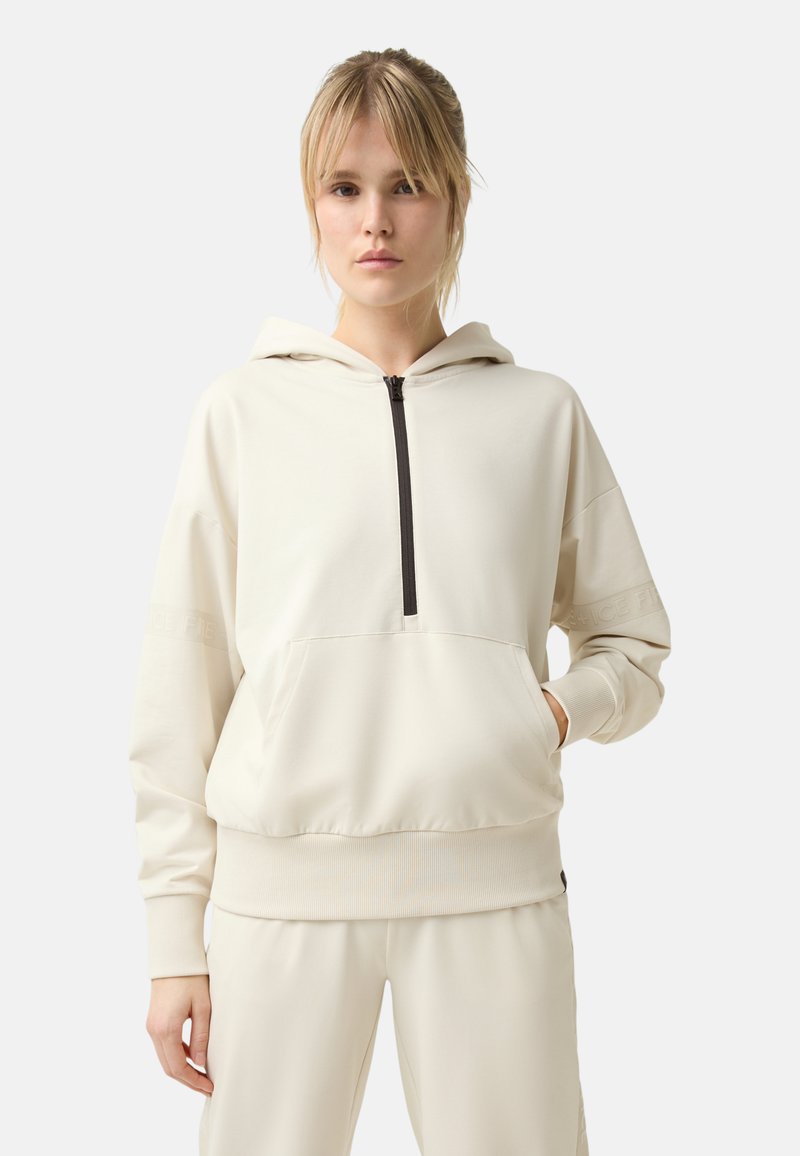 Helle beige Kapuzenjacke mit einem Frontreißverschluss, Kängurutasche, gerippten Bündchen und Saum. Mit gesticktem Logo-Detail am Ärmel. Weiche Stofftextur.