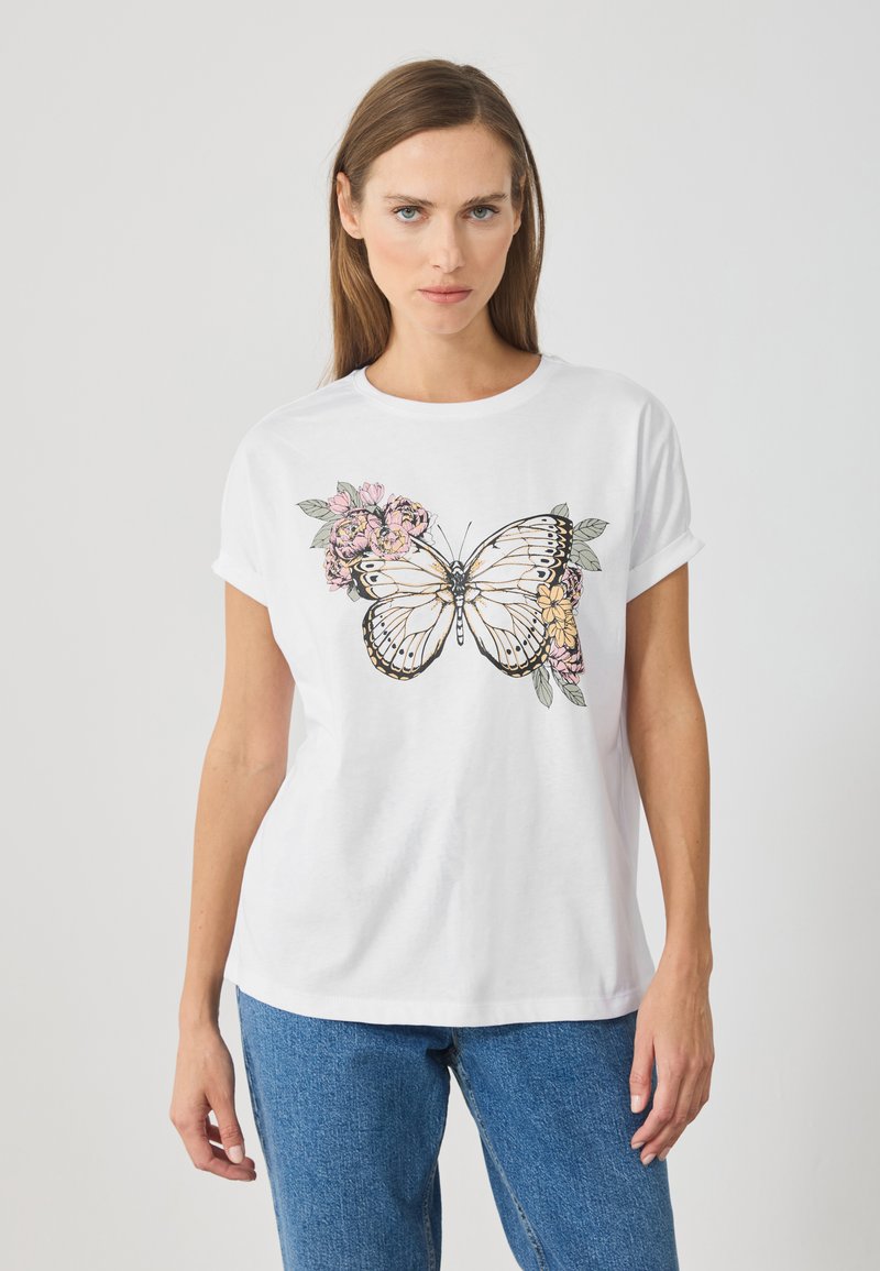 Hvid bomulds t-shirt med et stort sommerfugl grafik, accentueret med rosa og gule blomsterdesigns på hver side. Korte oprullede ærmer.