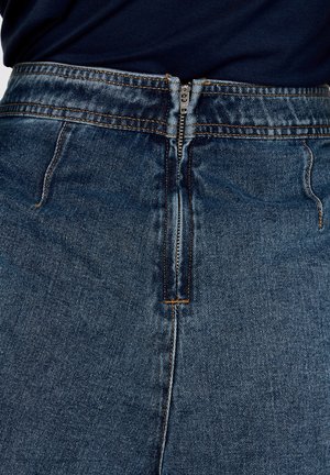 Gonna in denim a vita alta, con chiusura a zip frontale, lavaggio blu scuro e cuciture arancioni a contrasto lungo le cuciture.