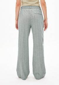 Lichtgroene, wijde broek met verticale strepen, elastische tailleband en een achterzak, gemaakt van een zachte, gestructureerde stof.