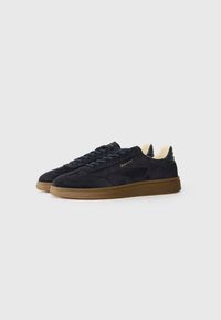 Adidași din suede negru cu talpă din cauciuc, având vârf rotund, design cu șireturi și brand aurit pe lateral. Accente interioare de culoare deschisă.