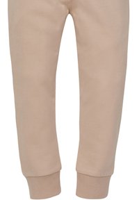 Beige Jogginghosen aus weichem Stoff, mit schmal zulaufendem Design und gerippten Knöchelbündchen. Minimalistischer Stil ohne sichtbare Muster oder Hardware.
