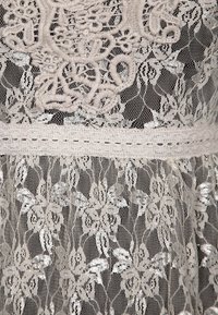 Kermakankainen pitsikangas, jossa on monimutkaisia kukkakuvioita ja teksturoitua brodeerausta. Vyötäröllä on vaakasuora nauha. Pehmeä ja herkkä ulkonäkö.