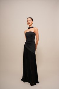 Black evening gown featuring a strapless, fitted bodice with a high neck and asymmetrical draped skirt. Material: smooth fabric with a sheer overlay.
