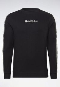 Sweat-shirt noir à manches longues Reebok en tissu texturé, logo blanc sur la poitrine et bandes à motifs brandés le long des deux manches.