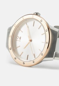 Silberne Uhr mit einem runden Gehäuse, roségoldener Lünette, strukturiertem weißen Zifferblatt, Stundenmarkierungen und Steinen. Metallarmband mit gebürsteter Oberfläche.