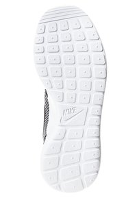 Black and white Nike shoe sole featuring a textured rubber surface with hexagonal patterns and a branded logo embossed in the center.