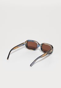 Plastic sunglasses with a square shape, colorful marbled frame in blue and brown, and brown tinted lenses. Features thick arms with logo detail.