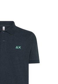 Polo shirt navy con maniche corte, dotato di un colletto e due bottoni. Logo geometrico verde notevole sul lato sinistro del petto. Texture liscia.