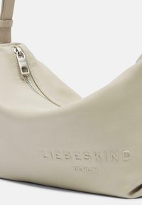 Borsa a spalla in pelle beige con una texture liscia. Caratterizzata da una zip argentata e il logo in rilievo "LIEBESKIND BERLIN" su un lato.