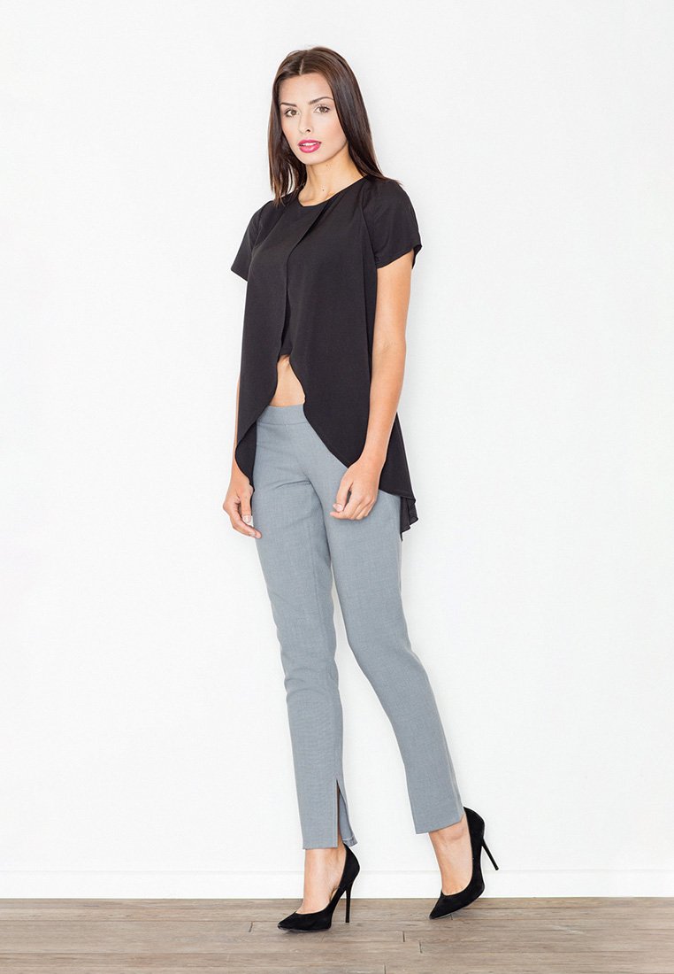 Czarna bluzka z krótkimi rękawami i asymetrycznym dołem w połączeniu z jasnoszarymi dopasowanymi spodniami z bocznymi rozcięciami. Modelka nosi czarne szpilki.