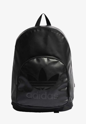 Mochila negra Adidas con gran bolsillo frontal, asa superior y logotipo de trébol en relieve y nombre de la marca en el bolsillo.