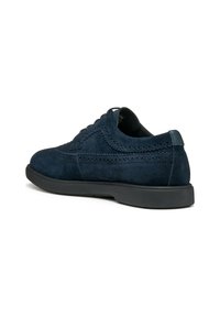Scarpa in suede blu navy con finitura liscia, caratterizzata da dettagli brogue lungo le cuciture, una suola nera in gomma bassa e un design con lacci.