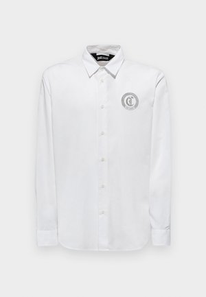 Camicia bianca a maniche lunghe con bottoni realizzata in cotone liscio. Presenta una toppa rotonda con logo grigio sul lato sinistro del petto. Design con colletto classico.