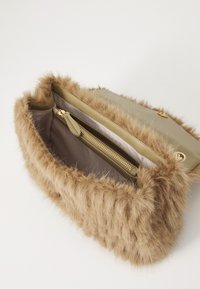 Borsa in pelliccia sintetica marrone con una base in pelle liscia beige. Presenta una tasca interna con zip e una chiusura a pulsante in tonalità oro.