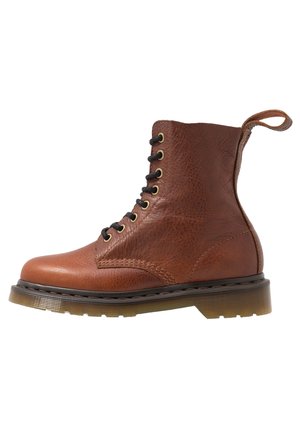 Brązowy skórzany botek na sznurówki z grubą przezroczystą gumową podeszwą i pętelką z tyłu.