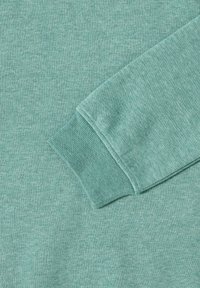 Ljust teal sweatshirt tyg med en strukturerad, mjuk finish. Muddarna har ribbad stickning som smälter samman med huvudfärgen.