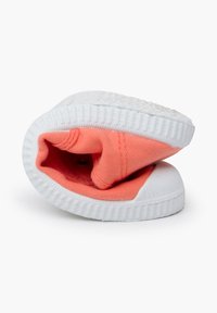 Scarpa di tela corallo con suola in gomma bianca, caratterizzata da un design slip-on e un interno foderato in tessuto corallo abbinato.