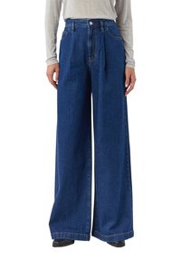 Spodnie dżinsowe o szerokich nogawkach w ciemnym niebieskim kolorze, z wysokim stanem, szlufkami na pasek, przednimi kieszeniami i wyraźnym przeszyciem.
