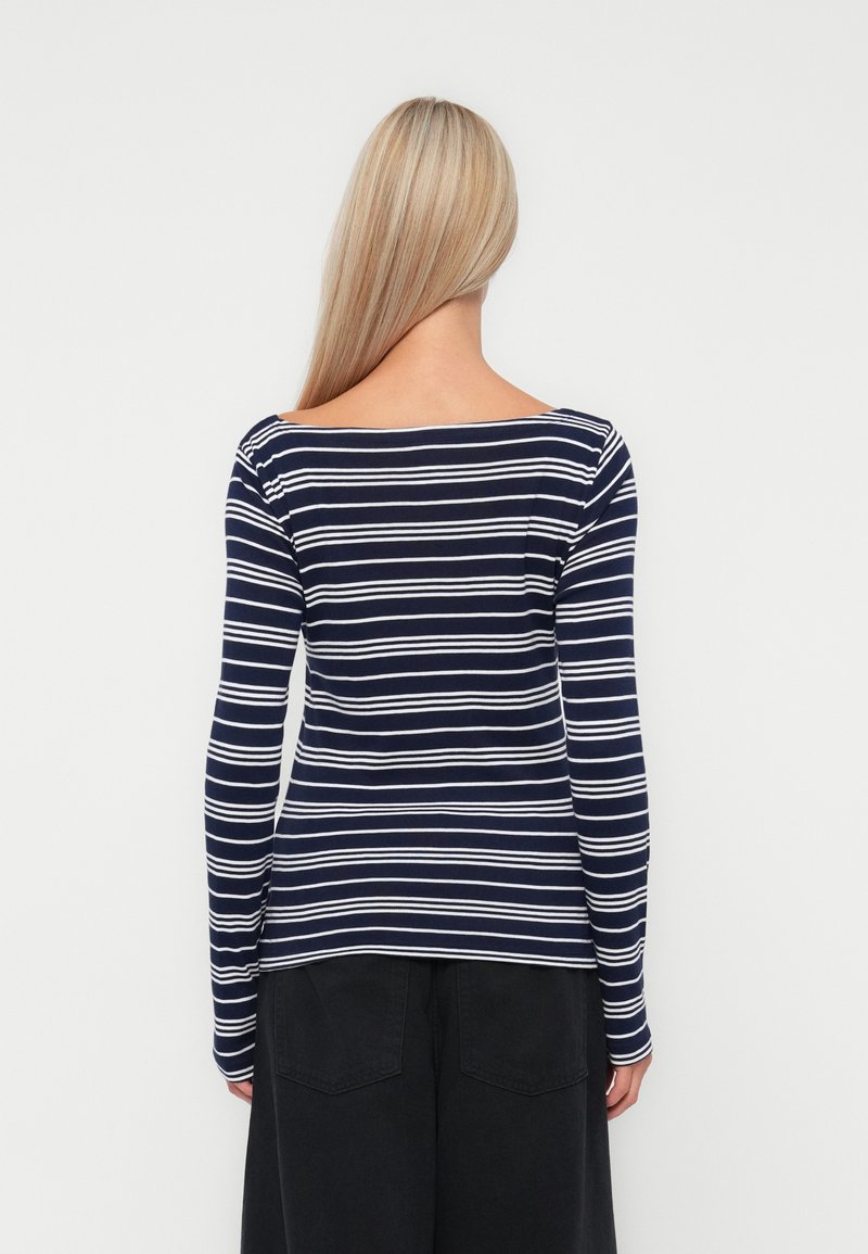 Langärmliges Oberteil in marineblau-weißen Streifen, aus einem weichen Strickmaterial gefertigt, mit weitem Halsauschnitt und figurbetontem Design.