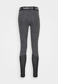 Svarta och grå leggings med ett texturerat mönster, som har en helsvart nedre del och en tjock logobrand.