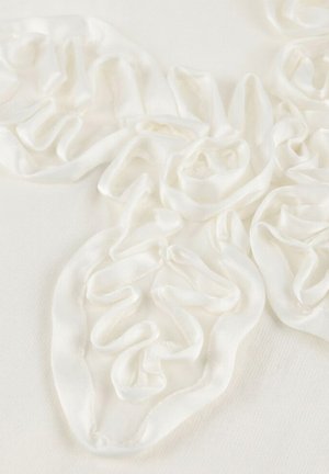 Witte stof met delicate, verhoogde lintdetails in de vorm van rozen die een gestructureerd bloemmotief vormen.