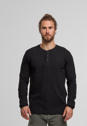 Maglietta a maniche lunghe nera in stile henley, con texture a coste, colletto tondo, placket con cinque bottoni, design aderente, colore uniforme, stile casual senza motivi.