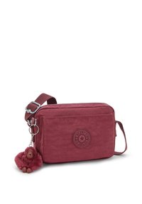 Rød stof crossbody taske med en tekstureret overflade, logo-patch, lynlåslukning, justerbar skulderrem og en monkey nøglesnor som tilbehør.