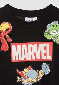 Felpa nera con scollo a costine che presenta adesivi colorati di personaggi Marvel: Iron Man, Hulk e Thor, con un audace logo "MARVEL" rosso.
