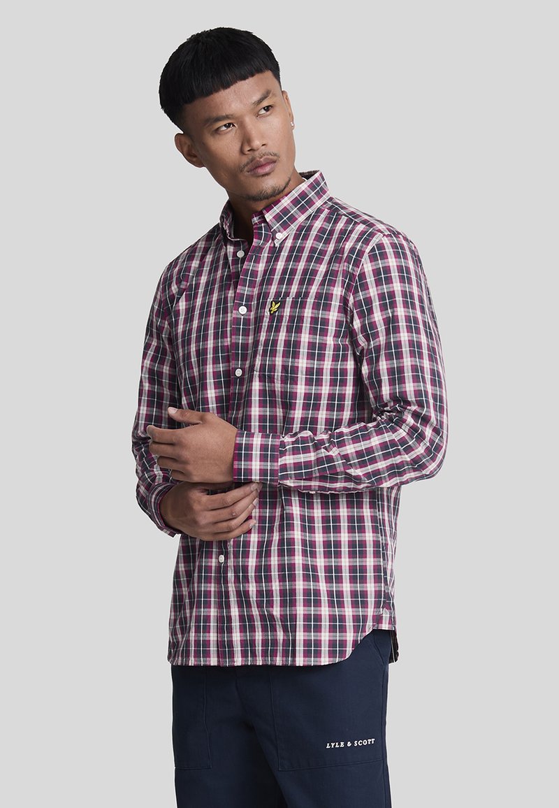 Camicia a maniche lunghe a quadri rossi e navy con colletto pieghevole, logo giallo piccolo sul lato sinistro del petto. Tessuto in misto cotone.