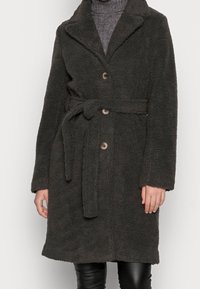 Abrigo de un gris oscuro, esponjoso, con cuello chal, dos botones en la parte frontal y un cinturón en la cintura. Presenta mangas largas y una tela suave con textura.