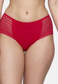 Bas de bikini rouge avec panneaux latéraux en dentelle présentant un motif en diamant et des bords festonnés. Texture lisse, design mi-haut.