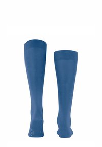 Calze al ginocchio di colore blu solido, realizzate in un materiale liscio e elastico, con bordi a coste e suole rinforzate, caratterizzate da un branding minimale.