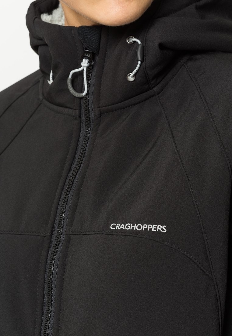 Schwarze Softshell-Hybridjacke mit Reißverschluss, Fleecefutter und reflektierenden Hardware-Elementen. Craghoppers-Logo auf der linken Brustseite.
