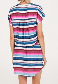 Robe rayée à manches courtes, présentant des rayures horizontales bleues, roses et bordeaux. Détail plissé au dos, forme fluide. Matériau doux.