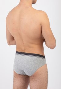 Slip in cotone grigio con un elastico a strisce bianche e nere in vita, caratterizzato da un design aderente e una texture liscia.