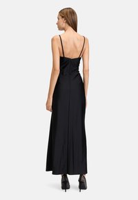 Schwarzes Satin-Abendkleid mit dünnen Spaghettiträgern, tailliertem Oberteil und einem langen, fließenden Rock. Verfügt über einen Reißverschluss im Rücken.