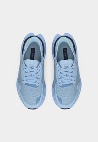 Ζευγάρι ανοιχτό μπλε πλεκτά αθλητικά παπούτσια με κορδόνια, από πάνω, σε λευκό φόντο.