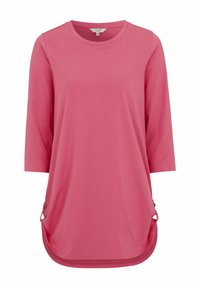 Vaaleanpunainen pitkähihaisuus paita, jossa on pyöreä pääntie ja kaareva helma. Siinä on sivuaksentteja, joissa on metalliyksityiskohtia, sekä sileä, kevyt kangas.