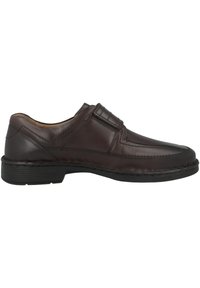 Brown leather shoe with a rounded toe and stitching details. Low-profile black rubber sole and decorative accents on the upper part.