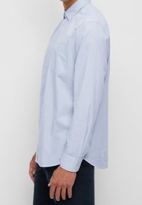Camicia button-up a righe azzurro chiaro, con maniche lunghe, taschino sul petto e polsini abbottonati. Realizzata in tessuto di cotone intrecciato.
