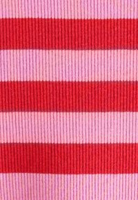 Pruhovaná látka s striedavými vodorovnými pásmi tmavočervenej, svetločervenej a ružovej farby. Textúra je rebrovaná, čo zvyšuje vizuálnu hĺbku.