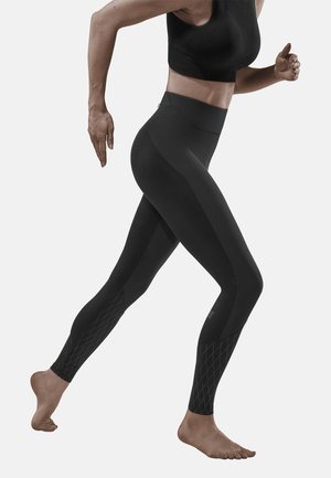 Schwarze Sportleggings mit hoher Taille, die über strukturierte Rautenmuster in der Nähe der Knöchel und eine figurbetonte Passform für optimale Bewegungsfreiheit verfügen.