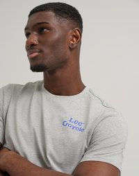 T-shirt grigia a maniche corte con logo blu "Lee Crayola". Il collo presenta un discreto dettaglio di cucitura verde. Tessuto morbido.
