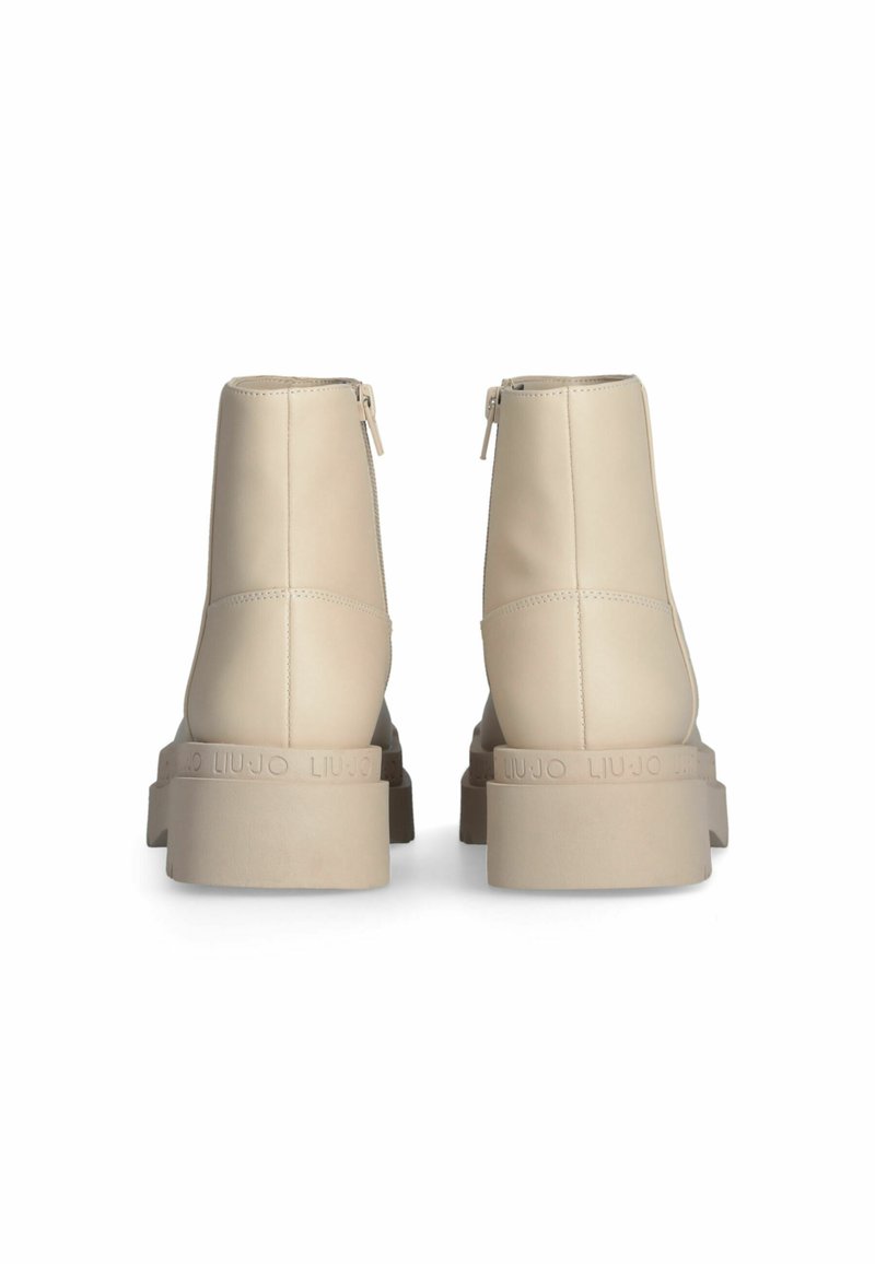 Beige Knöchelstiefel mit einem glatten Obermaterial aus Kunstleder, runder Zehenpartie, seitlichen Reißverschlüssen und einer klobigen, strukturierten Plattformsohle.
